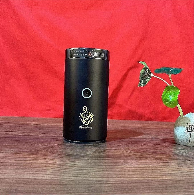 The Bluetooth Bakhoor Burner, black cylindrical electric bakhoor burner by SmartMuslim with a round power button.