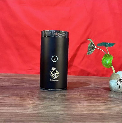 The Bluetooth Bakhoor Burner, black cylindrical electric bakhoor burner by SmartMuslim with a round power button.