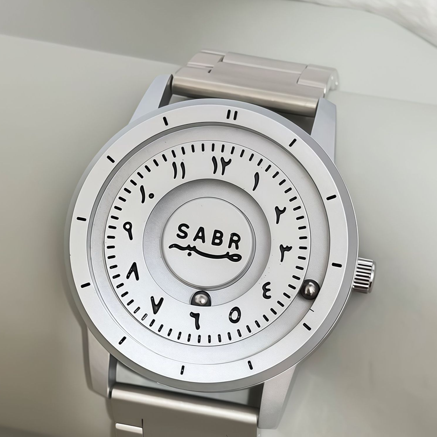 Sabr Watch by SmartMuslim, silver stainless steel Islamic wristwatch with Arabic numerals.