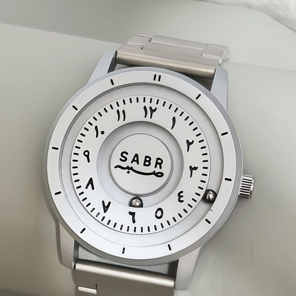 Sabr Watch by SmartMuslim, silver stainless steel Islamic wristwatch with Arabic numerals.